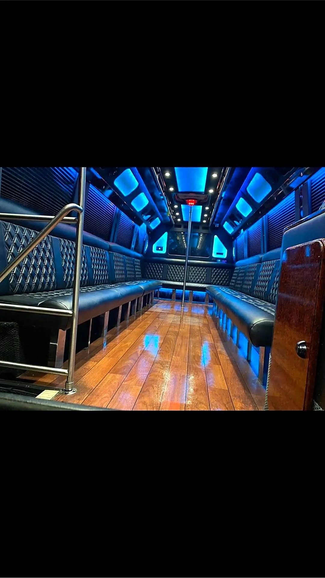 Bus interior photograph with blue lighting and wood flooring