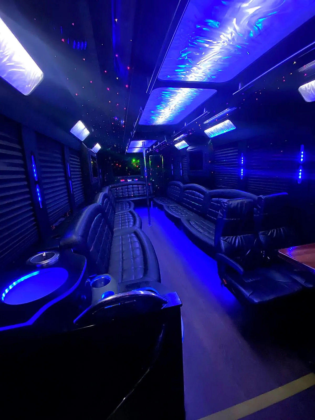 Bus seating and ceiling illuminated by blue lighting